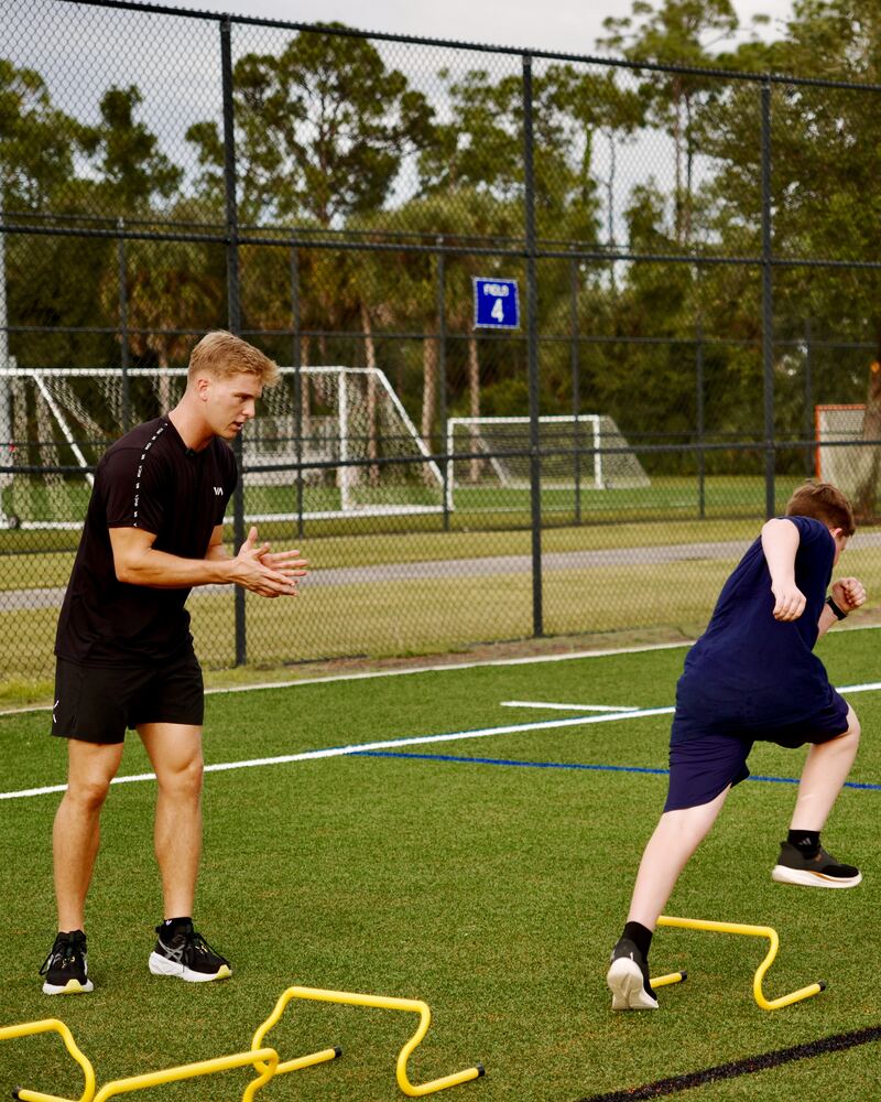 FutureBuilt coach cueing an athlete through a hurdle hop drill at North Collier Regional Park