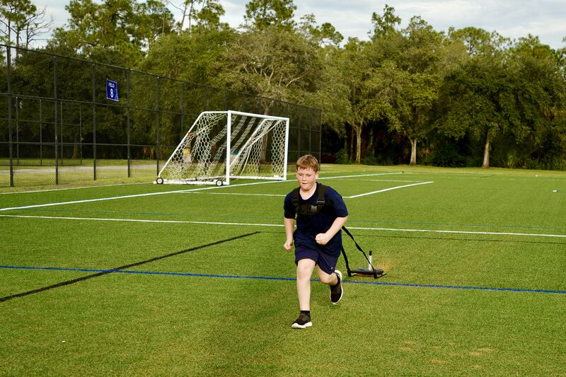 Athlete sprinting while pulling a weighted sled across the field